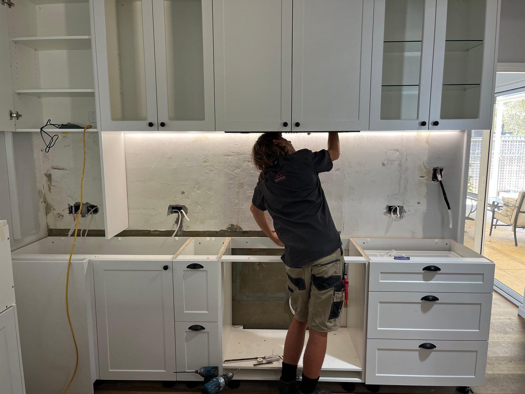 Electrician fitting off power and lighting during a kitchen renovation